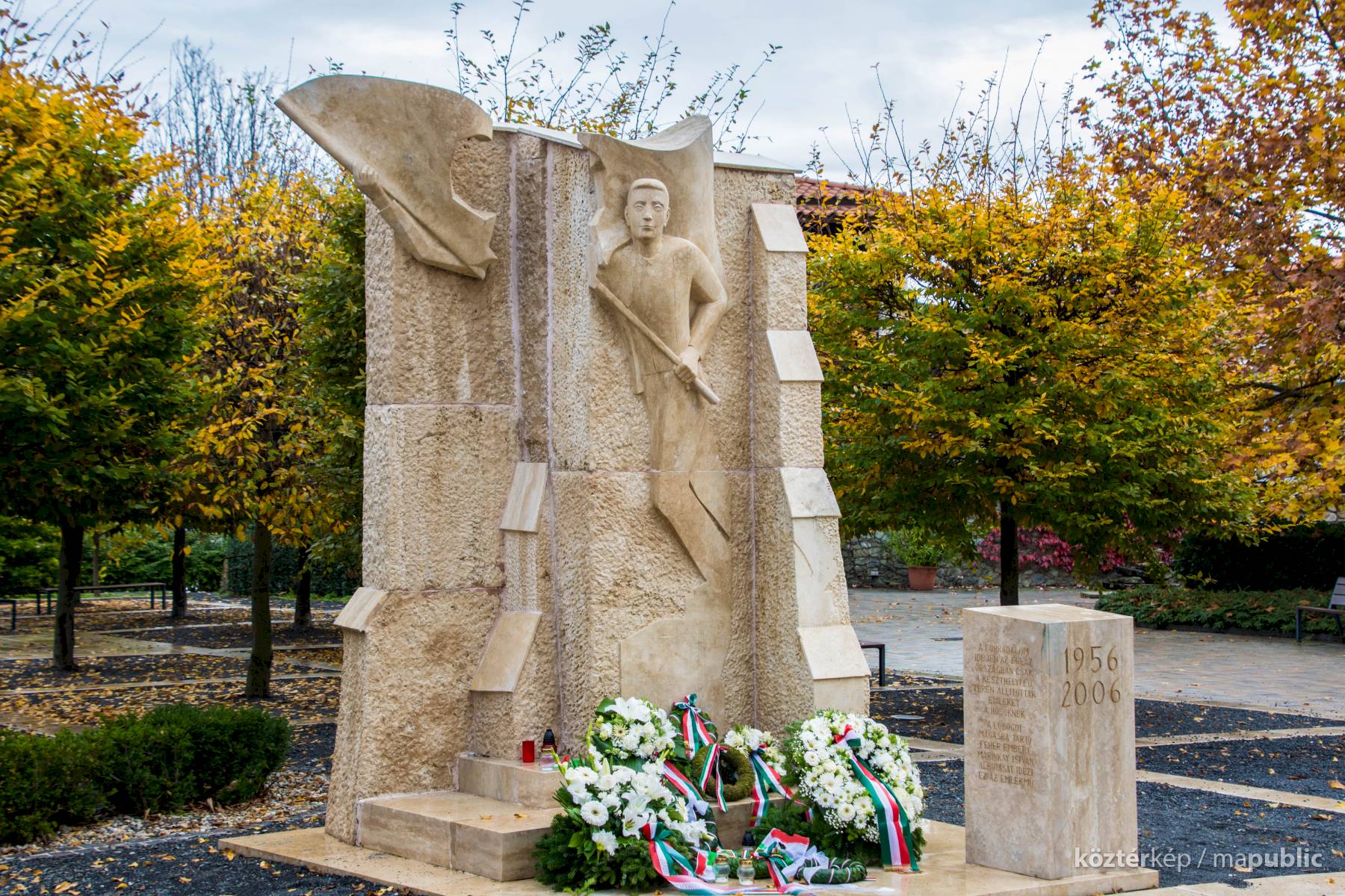 Orr Lajos 2006-os 1956-os emlékműve Keszthelyen, az őszi fák között, koszorúkkal a talapzatán.